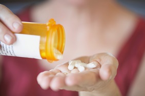 woman pouring pills onto her hand