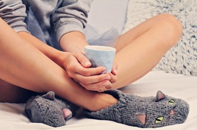 woman wearing slippers and holding a mug
