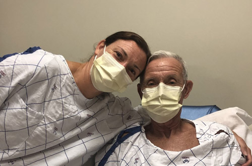 Brooke and Donald wearing hospital gowns and masks 
