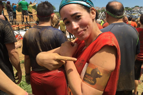 Young Female MS Patient Rachael Proudly points to her shoulder badge during the Philadelphia Muckfest during the mud run for MS