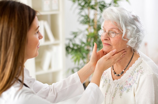 doctor examining a woman's thyroid