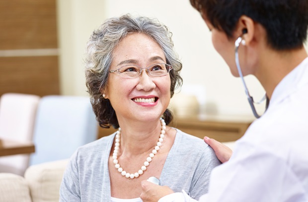 Doctor listening to a woman's heart