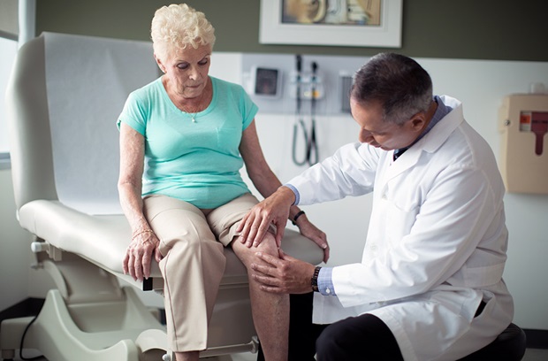 Doctor squeezing patient's knee