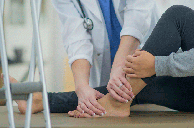 Patient sitting on floor while the provider holds her foot and ankle