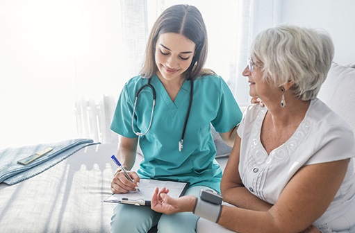 nurse checking grandma's blood pressure 