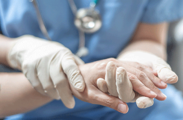 Provider wearing gloves while holding patient's hand