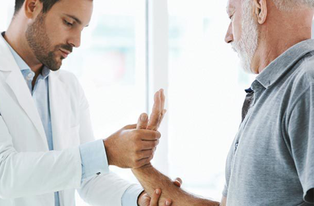 Provider holding patient's arm and pushing on hand