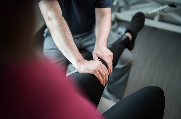 Provider stretching knee of patient