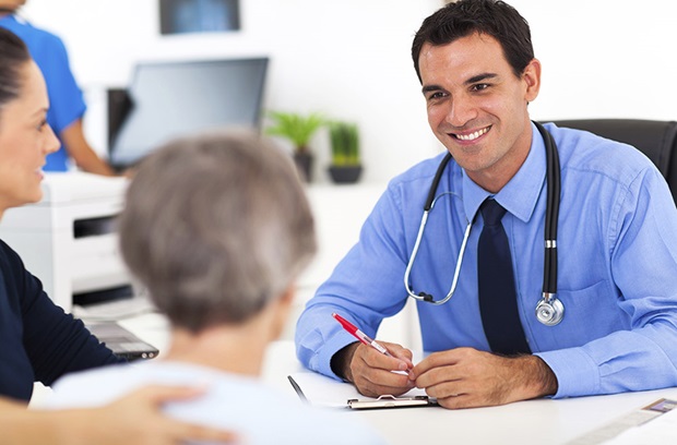 Smiling doctor sitting with patients