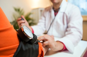 Doctor taking patient's blood pressure