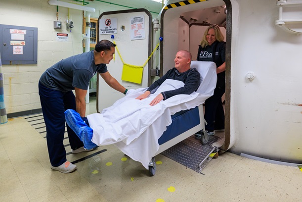 patients are helped in and out of the chamber