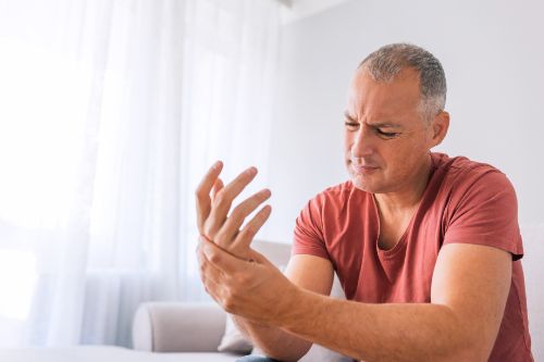 man holding hand in pain