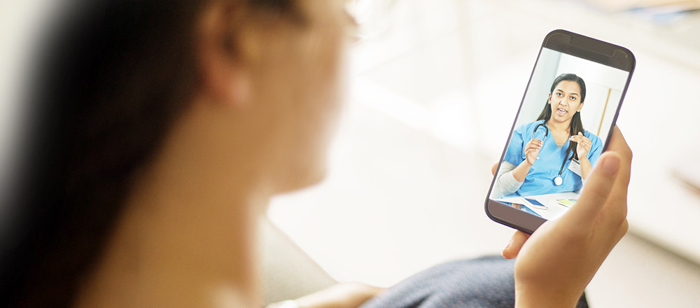 Doctor talking to a patient via video chat. The patient is viewing the chat on a smartphone.