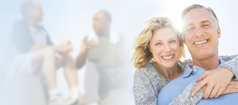 Older couple hugging and smiling at camera